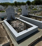 Muslim monument with crescent and star, inscription in carved white letters, ornaments, pedestal, tiled curb, concrete base