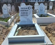 Muslim monument with crescent and star, wheel of life pattern, inscription in carved black letters, pedestal, tiled curb, cement path, concrete base