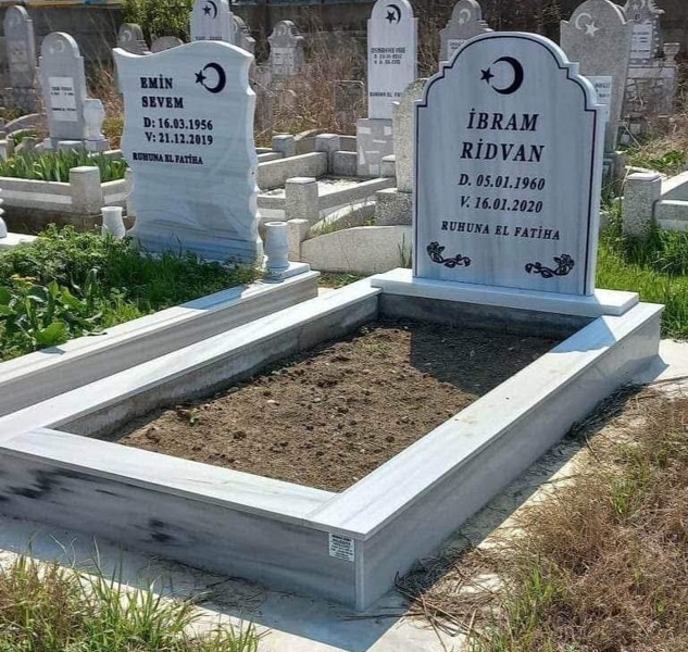 Muslim monument with crescent and star, inscription in carved black letters, ornaments, pedestal, tiled curb, concrete path, concrete base