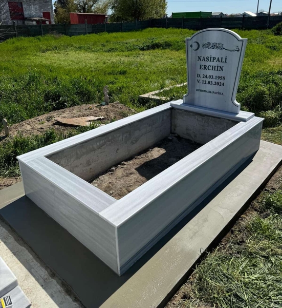 Muslim monument with crescent and star, inscription in carved black letters, ornaments, pedestal, high tiled curb, concrete path, concrete base