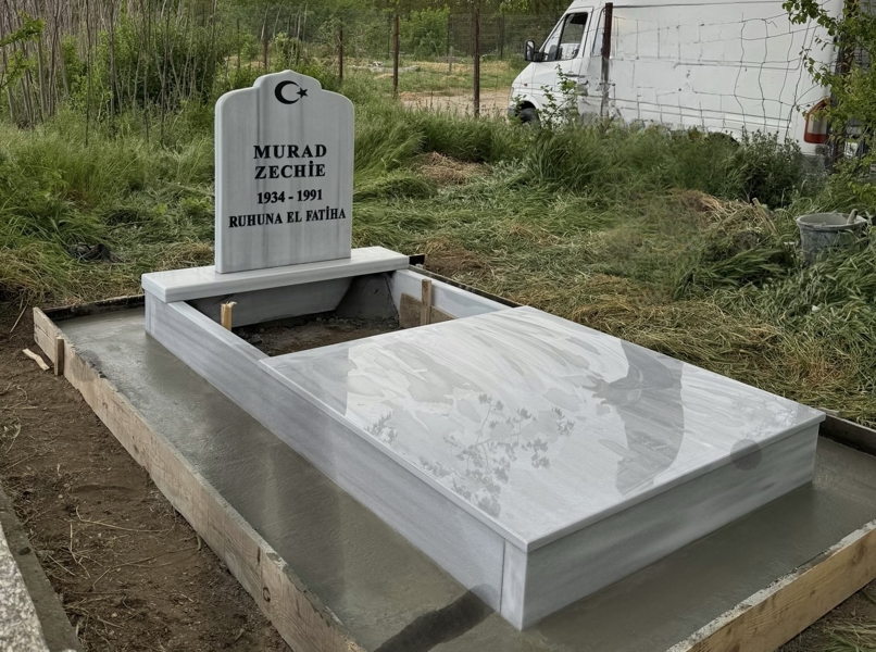 Muslim monument with crescent and star, inscription in carved black letters, pedestal, high massive curb, roof slab to the middle, cement path, concrete base