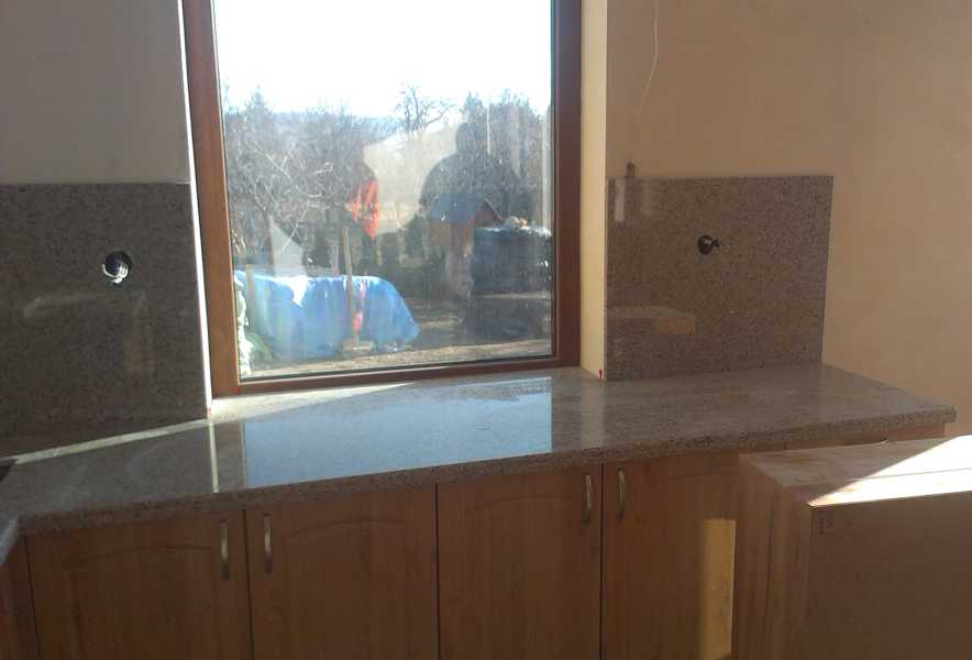 Монтирани гърбове на кухня около прозорец заедно с перваз и плот