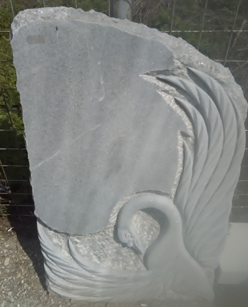 Фигура на лебед, издълбана в плочата на паметник от сив мрамор