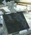 Надгробен паметник тип възглавница с масивен мраморен кръст и черна плоча, с гравирани портрет, надпис и изправен кон, със страни от сив мрамор