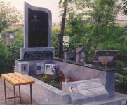 Мраморен паметник, с вградена плоча с нарисуван портрет в цял ръст на човек, седнал във фотьойл