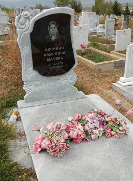 Паметник от сив мрамор, модел с обемна роза горе вляво и релефна роза долу вдясно, със залепена плоча от черен гранит, с гравиран портрет и надпис, постамент и покривна плоча, с чела отдолу, мраморна пътека.