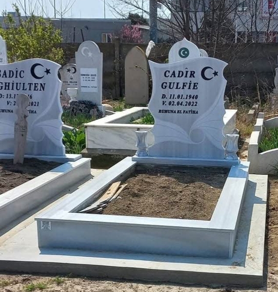 Monument musulman cu semilună și stea, inscripție cu litere negre sculptate, două vaze rotunde, piedestal, bordură din gresie, bază de beton