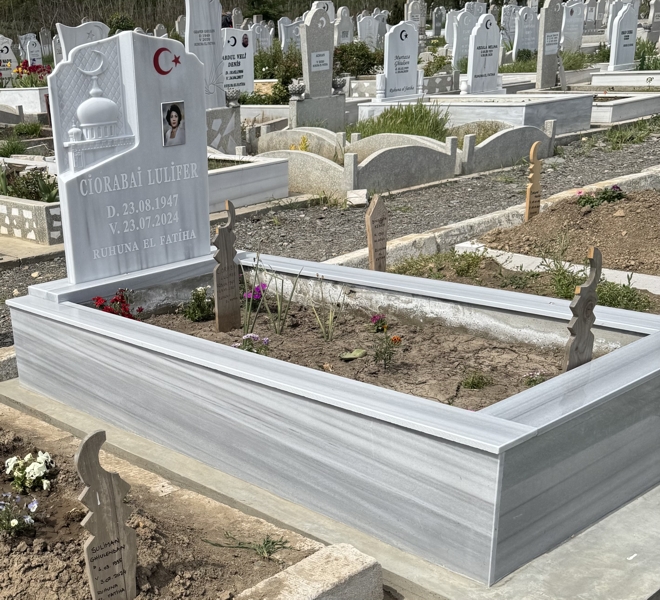 Monument musulman cu semilună și stea, fotografie dreptunghiulară colorată din porțelan, inscripție cu litere albe sculptate, piedestal, bordură înaltă cu gresie, bază din beton, vedere din stânga